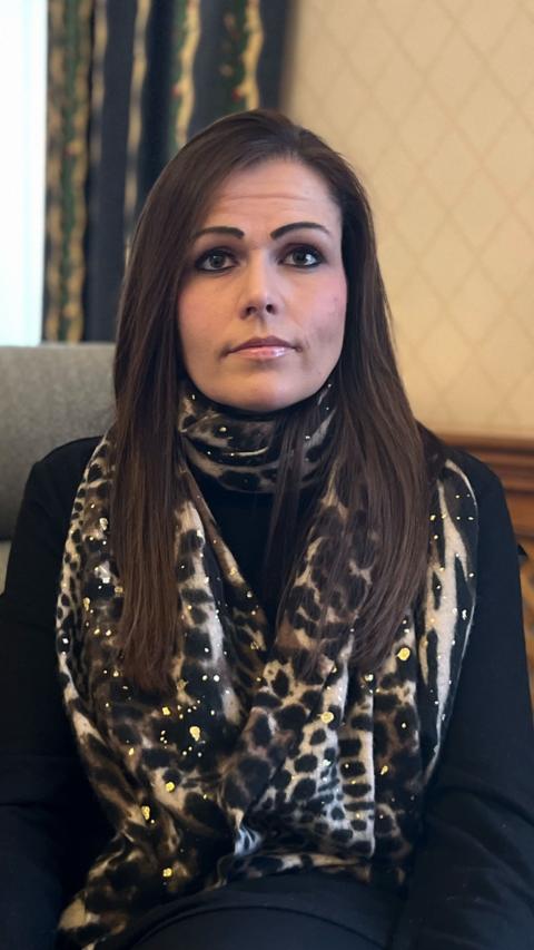 Women with long brown hair wearing a leopard print scarf looking directly at the camera