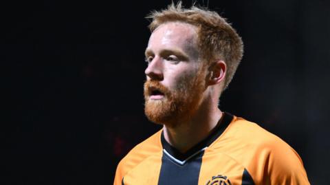 James Brophy looks on while playing in a game for Cambridge United.