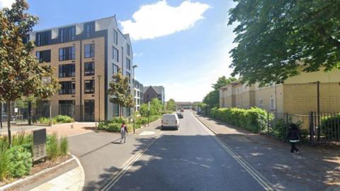 James Wolfe Road in Oxford on a Sunny day. Two women can be seen walking on the street away from the camera.