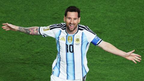Lionel Messi with arms outstretched celebrates scoring for Argentina