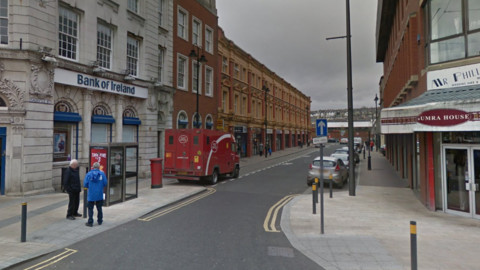 A screen grab of Sackville Street in Derry from Google Maps, showing a bank in the foreground and tall buildings lining the road