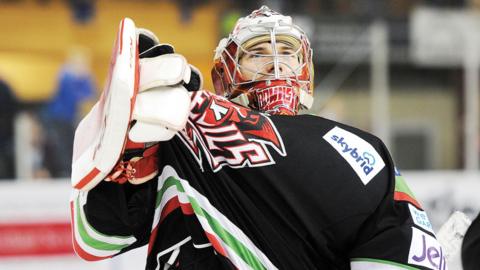 Ben Bowns in helmet pulls on the Devils logo of his black jersey with his gloved hand