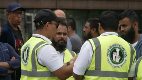 Drivers in reflective bibs talk to one another at the protest on Wednesday