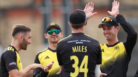 Gloucestershire players celebrate a wicket with Craig Miles (with his back turned) getting a high-five 