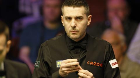 Mark Selby chalks his cue