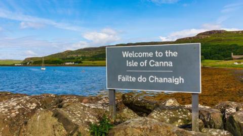 A sign on the island of Canna in English and Gaelic reading 'Welcome to to the Isle of Canna'