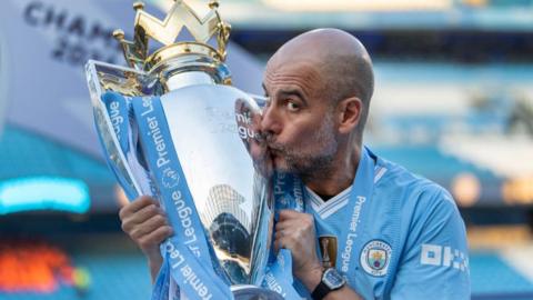 Manchester City boss Pep Guardiola kisses the Premier League trophy