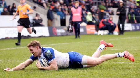 Smiling Bath wing Ruaridh McConnochie dives over to score a try against Sale Sharks