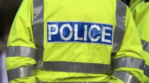 A picture of the back of a police officer wearing a hi-vis police jacket