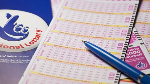 Close up of national lottery strips with a blue pen