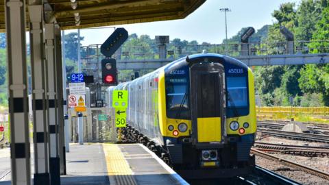 Train leaving the station platform  and heading to Alton in Hampshire