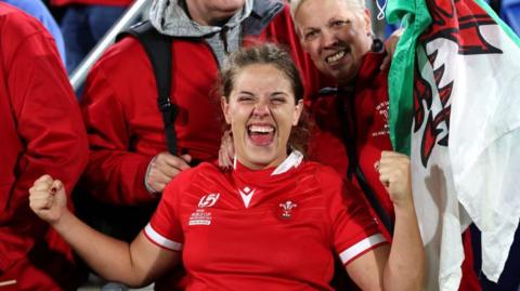 Natalia John celebrates victory with her family and a Welsh flag