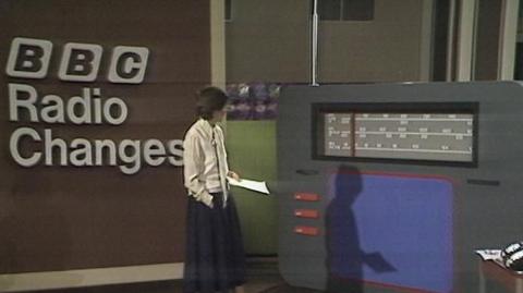 Sue Lawley in front of a large radio prop.