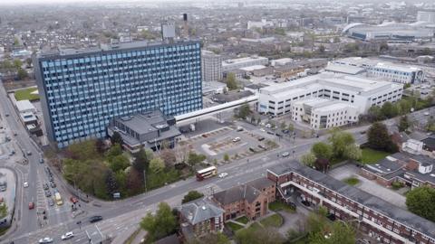 An aerial shot of the front of Hull Royal Infirmary with the glass high-rise main building on the left and the lower main building to the right