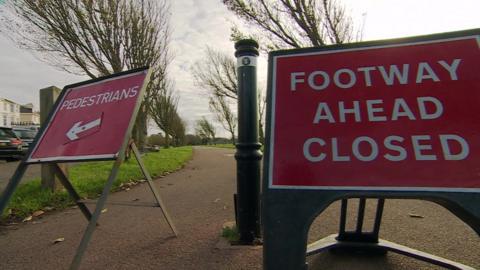 Red road closed signage on a footpath