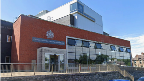 Caernarfon Crown Court exterior, a red brick building with a big wall of windows