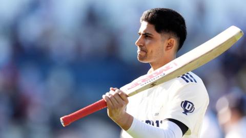 Shubman Gill raises his bat after hitting a century