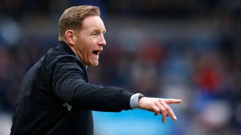 Shrewsbury Town boss Gavin Cowan points and shouts instructions during a game