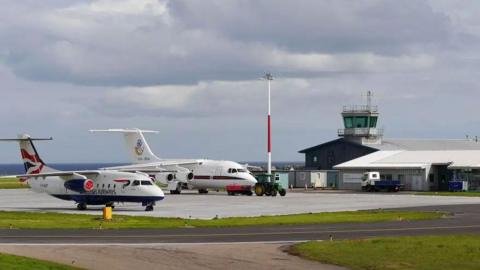 Wick John O'Groats Airport with two planes sitting out in front of a hangar building and control tower