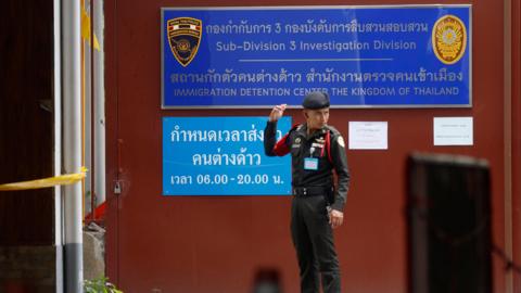 A security guard stands outside the immigration detention center at the Immigration Bureau in Bangkok