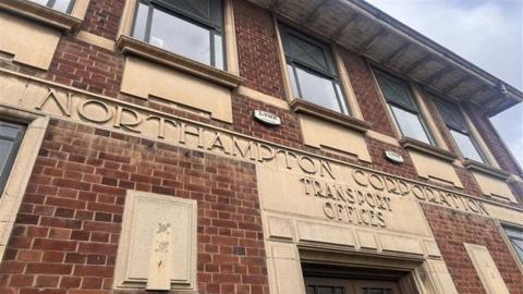 Red brick building with a stone sign saying Northampton Corporation Transport Offices.