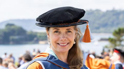 Dame Darcey Bussell in a university graduation gown and doctorate soft hat