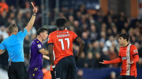 The referee shows a red card to Luton's Liam Walsh during their 14 December game against Blackburn