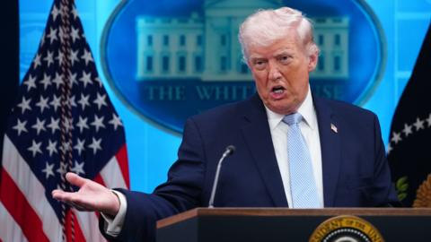 Donald Trump speaking at the podium on 6 April.