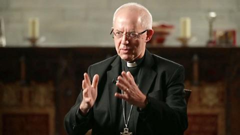 Justin Welby wearing a black blazer, glasses and clerical collar