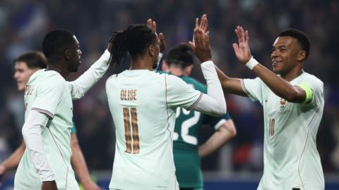 Michael Olise celebrates with Kylian Mbappe