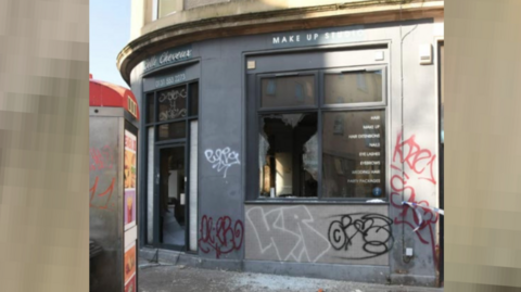 The fire-damaged Belle Cheveux salon has smashed windows and graffiti on the outside walls