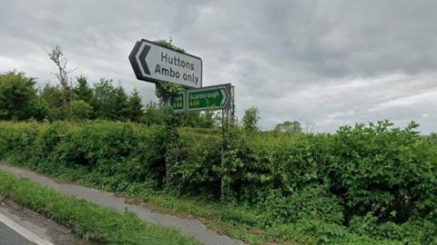 Road signs on the A64, pointing to York and Scarborough, as well as Huttons and Ambo
