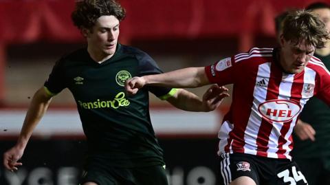 Ben Krauhaus challenges for the ball for Brentford v Exeter