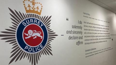 The Surrey Police logo painted on a white internal wall