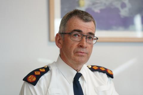 Garda Commissioner Drew Harris looks straight at the camera in an office setting