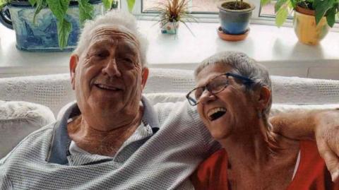 Alan and Ann Shawyer sitting on the sofa in their home