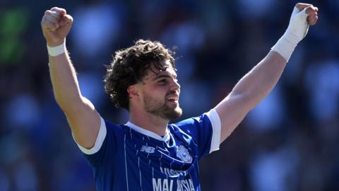Ollie Tanner raises his arms to celebrate scoring for Cardiff