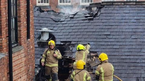 Firefighters pictured on top of the roof in Ilkeston