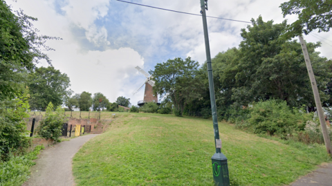 A park area with a windmill in the background