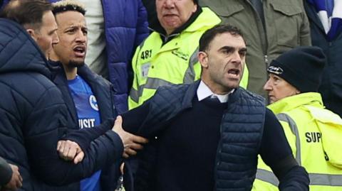 Omer Riza being held back by Cardiff City striker Callum Robinson after their win over rivals Swansea City