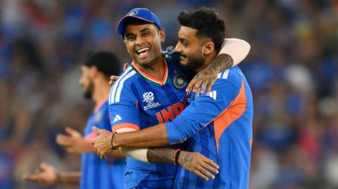 India captain Suryakumar Yadav (left) hugs spinner Axar Patel (right) after he takes a wicke