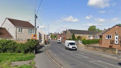 Street view of White Apron Street shows two white vans driving down the road with rows of houses on either side