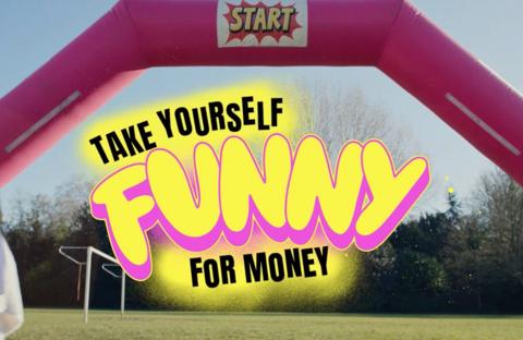 A bouncey castle on a playing field with the logo Take Yourself funny for money. 