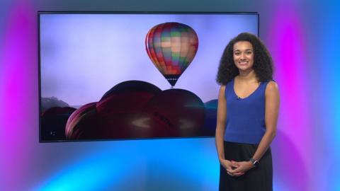 Nina Blissett next to a picture of a hot air balloon. 