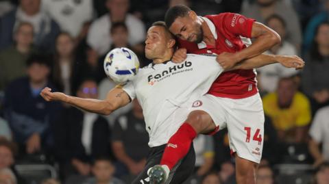 Derby County striker Carlton Morris has his shirt pulled by Bristol City defender Zak Vyner