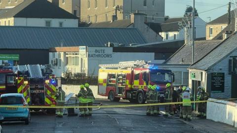 Two fire engines and firefighters on King Street, Castle Douglas outside Moore's Chip Shop. 