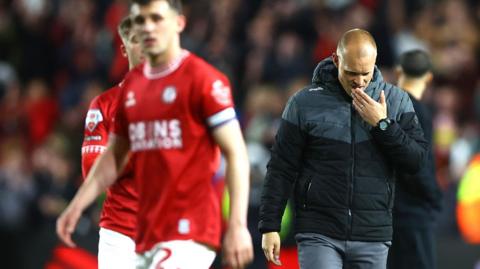 Liam Manning (right) looks despondent at full-time