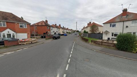 A generic photo showing Regent Street going from the bottom left to the centre of the photo. It is pictured at the junction with Pine Tree Road, which is on the right. Houses and cars are on both sides of Regent Street.  