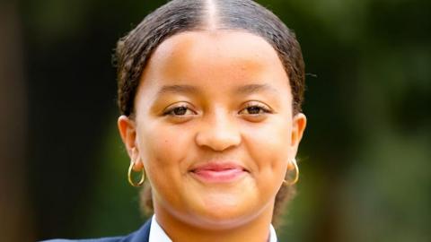 A headshot of Ellyanne Wanjiku Chlystun looking at the camera and smiling.