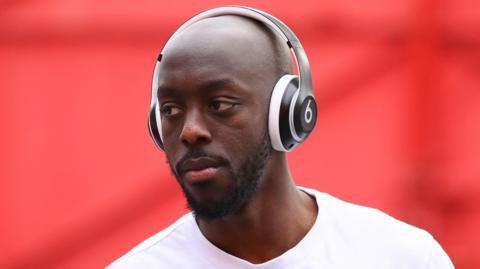 Yoane Wissa arriving at Brentford with a pair of headphones on